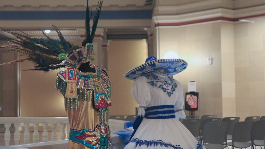 A traditional competitive women's charro costume (right) is displayed next to a replica of Aztec garments (left) designed by Imelda Juarez at the Hispanic Cultural Day celebration. Pictures: Kevin Palomino